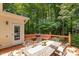 An inviting backyard deck includes a charming outdoor table and built-in seating surrounded by lush greenery and natural light at 105 Windfall Ct, Cary, NC 27518
