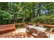A wooden deck features outdoor seating, creating a peaceful retreat surrounded by lush greenery and mature trees at 105 Windfall Ct, Cary, NC 27518