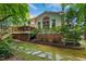 Backyard view with a deck, brick foundation and stone pathway surrounded by lush greenery at 105 Windfall Ct, Cary, NC 27518