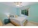 Comfortable bedroom bathed in natural light, featuring a ceiling fan and a large window overlooking the trees at 105 Windfall Ct, Cary, NC 27518
