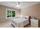 Cozy bedroom with a ceiling fan and a window providing natural light with a view of the surrounding trees at 105 Windfall Ct, Cary, NC 27518