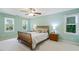 A serene bedroom with a ceiling fan, two windows, and stylish wood furniture creates a calm retreat at 105 Windfall Ct, Cary, NC 27518