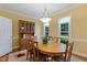 A dining room featuring a wood table, chandelier, and built-in hutch creating a warm space at 105 Windfall Ct, Cary, NC 27518