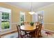 A dining room with a wood table is brightened by windows and complemented by a neutral rug at 105 Windfall Ct, Cary, NC 27518