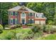 Charming two-story brick home with blue shutters, a manicured lawn, and beautiful landscaping at 105 Windfall Ct, Cary, NC 27518
