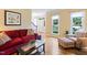 A cozy living room with a red sofa, striped armchair, and wood floors exudes warmth and style at 105 Windfall Ct, Cary, NC 27518