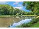 Scenic view of a pond reflecting the sky and surrounding trees, enhancing the property's tranquility at 105 Windfall Ct, Cary, NC 27518
