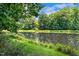 Picturesque view of a pond reflecting the sky and surrounding lush greenery, creating a serene atmosphere at 105 Windfall Ct, Cary, NC 27518