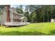 Exterior backyard view with a large wooden deck, green grass, and well-maintained vinyl siding at 10721 Marabou Ct, Raleigh, NC 27614