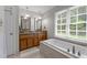 Spacious bathroom with soaking tub, double sinks, granite counters, and linen closet at 10721 Marabou Ct, Raleigh, NC 27614