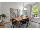 Airy dining room with hardwood floors, modern chandelier, and large windows for ample natural light at 10721 Marabou Ct, Raleigh, NC 27614