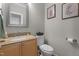 Cozy half bathroom with granite countertop, wooden vanity, and decorative wall art at 10721 Marabou Ct, Raleigh, NC 27614