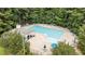 Aerial view of a large community pool surrounded by mature trees and lounging chairs at 10721 Marabou Ct, Raleigh, NC 27614