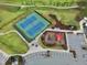 An aerial view shows a neighborhood tennis court and play area provide fun activities for residents at 108 Market Cross Ct, Holly Springs, NC 27540
