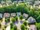 Aerial scene captures homes nestled among lush trees, creating a serene suburban setting with green landscaping at 108 Market Cross Ct, Holly Springs, NC 27540