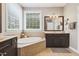 Bright bathroom with large tub and dark vanity at 108 Market Cross Ct, Holly Springs, NC 27540