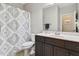 Bathroom featuring stylish patterned shower curtain, dark vanity with modern fixtures at 108 Market Cross Ct, Holly Springs, NC 27540