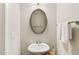 Stylish powder room with a pedestal sink, oval mirror, and clean, modern design at 108 Market Cross Ct, Holly Springs, NC 27540