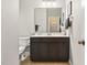 Bathroom featuring dark cabinets, a large mirror, and neutral wall paint at 108 Market Cross Ct, Holly Springs, NC 27540