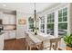 Bright dining room with hardwood floors, white table, and large windows offering natural light at 108 Market Cross Ct, Holly Springs, NC 27540