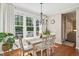 Sunlit dining room with large windows, elegant table setting, and hardwood floors for Gathering meals at 108 Market Cross Ct, Holly Springs, NC 27540
