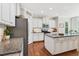 Bright kitchen with stainless steel appliances, granite counters, and an island offers ample workspace at 108 Market Cross Ct, Holly Springs, NC 27540