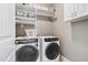 Laundry room with front load washer and dryer and storage shelves at 108 Market Cross Ct, Holly Springs, NC 27540