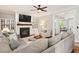 Cozy living room with fireplace, large sofa, and ceiling fan creates a comfortable gathering space at 108 Market Cross Ct, Holly Springs, NC 27540
