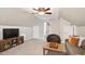 Spacious living room with vaulted ceiling, a cozy seating area, and entertainment center creating a versatile space at 108 Market Cross Ct, Holly Springs, NC 27540