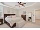 Bright main bedroom features a ceiling fan, tray ceiling, and ensuite bathroom access at 108 Market Cross Ct, Holly Springs, NC 27540