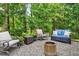 Inviting patio area with comfortable seating, fire pit and view of trees at 108 Market Cross Ct, Holly Springs, NC 27540