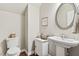 Classic powder room with pedestal sink, round mirror, and framed artwork provides an elegant touch at 108 Market Cross Ct, Holly Springs, NC 27540