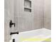 Close-up of bathtub with stylish black fixtures and tiled wall niche at 110 Broadleaf Ln, Louisburg, NC 27549