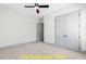 Carpeted bedroom featuring gray trim, ceiling fan, and double door closet at 110 Broadleaf Ln, Louisburg, NC 27549