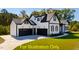 Exterior view of a modern two story home showcasing a well manicured lawn and three car garage at 110 Broadleaf Ln, Louisburg, NC 27549