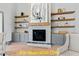 Close-up of the stone fireplace with floating shelves and gray built-in cabinets at 110 Broadleaf Ln, Louisburg, NC 27549