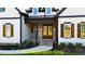 Inviting front entrance featuring a double door, gray brickwork, and a charming covered porch at 110 Broadleaf Ln, Louisburg, NC 27549