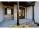 Charming front porch with brick accents, dark wood supports and stained double doors at 110 Broadleaf Ln, Louisburg, NC 27549