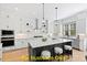 Modern kitchen with white cabinets, a center island, stainless steel appliances and hardwood floors at 110 Broadleaf Ln, Louisburg, NC 27549