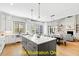 Open concept kitchen featuring a large island, stainless steel appliances, and hardwood flooring at 110 Broadleaf Ln, Louisburg, NC 27549