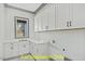 Functional laundry room featuring ample cabinet space, quartz countertops, and a window at 110 Broadleaf Ln, Louisburg, NC 27549