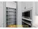 Walk-in pantry with built-in shelving, stainless steel oven and microwave in modern kitchen at 110 Broadleaf Ln, Louisburg, NC 27549