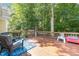 Back deck with patio furniture, a blue outdoor rug, and a lush, treed yard at 11901 N North Exeter Way Way, Raleigh, NC 27613