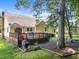 Backyard view with a deck, patio, hammock, lush lawn, and surrounding trees at 11901 N North Exeter Way Way, Raleigh, NC 27613