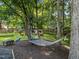 Secluded backyard hammock, fire pit and seating area nestled among mature trees at 11901 N North Exeter Way Way, Raleigh, NC 27613