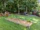 Expansive backyard showcasing a garden, playset, and seating area with mature trees at 11901 N North Exeter Way Way, Raleigh, NC 27613
