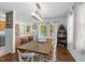 Open dining area with a large wooden table, open to kitchen, with a view to the outdoors at 11901 N North Exeter Way Way, Raleigh, NC 27613