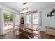 Bright dining area with a rustic table, bench seating, and sliding glass doors at 11901 N North Exeter Way Way, Raleigh, NC 27613