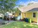 Backyard with deck, seating, lush lawn, and yellow house, all surrounded by trees at 11901 N North Exeter Way Way, Raleigh, NC 27613