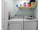Functional laundry room featuring a washer, dryer, and shelf space for storage at 11901 N North Exeter Way Way, Raleigh, NC 27613